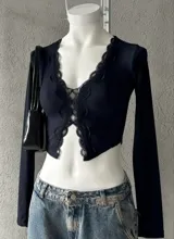 Remera corta negra de punto canalé con escote en V y detalles de encaje.