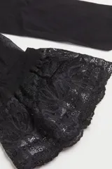 Medias hasta el muslo color negro, semi brillantes, de 20 deniers, con ribete de encaje y banda de silicona.