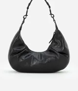 Bolso tipo baguette pequeño color negro con textura croco, correa de mano fina desmontable y cierre de cremallera.