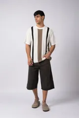Remera de hombre tejida en algodón color crudo, con textura piqué y rayas verticales marrones y negras.