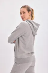 Campera deportiva gris claro con capucha, cierre frontal y bolsillos laterales.