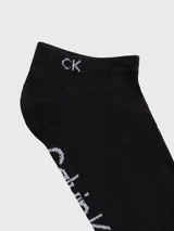 Pack de tres pares de medias tobilleras de punto, color negro, con el logo de Calvin Klein estampado en blanco alrededor del tobillo y las iniciales 'CK' en la parte superior.