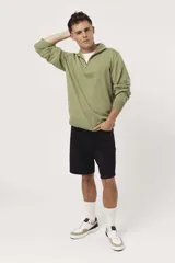 Sweater verde oliva de punto con cuello polo y cierre de cremallera parcial.