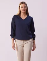 Blusa azul marino de gasa con escote en V y mangas largas con puño.