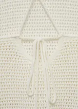 Top tejido al crochet color rosado, con cuello halter y tirantes finos.