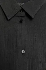 Camisa color durazno confeccionada en algodón, de corte amplio, con cuello solapa, manga larga con puños abotonados, hombros caídos, bolsillo de parche en el pecho, pinzas en la espalda y cierre frontal con botones.