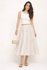 Falda midi de corte evasé confeccionada en lino de tono natural. Presenta un diseño de paneles con costuras decorativas en color beige que resaltan los recortes. Cuenta con cintura elastizada y caída fluida.
