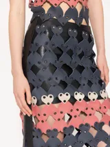 Pollera midi de cuero ovino con diseño de corazones troquelados en cuero vacuno y ojalillos metálicos níquel.