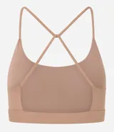 Top deportivo negro confeccionado en microfibra sin estampa, con espalda abierta y breteles finos cruzados.