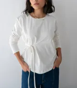 Remera blanca de manga larga con lazo en la cintura.