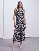 Vestido largo sin mangas, con escote en V cruzado y estampado floral en blanco sobre fondo negro.