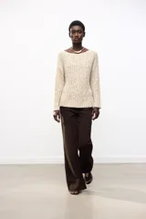 Sweater color crema de tejido de punto grueso, con cuello redondo amplio y mangas largas.