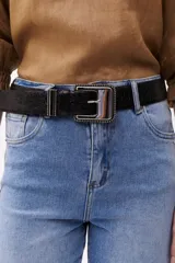 Cinturón marrón con hebilla metálica plateada con diseño de pequeñas esferas.