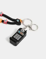 Llavero con dije de celular negro con teclado numérico y pantalla con la frase "Miss U". Incluye un strap de resorte negro con cuentas de colores y un dije con forma de cara.