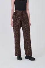 Pantalón de tiro alto, corte recto y largo, con estampado animal print de leopardo en tonos marrones y negros.