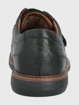 Zapato de cuero negro con ajuste de velcro, forro textil y plantilla de cuero y algodón orgánico. Suela de goma EVA con cortes para mayor flexibilidad.