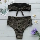 Conjunto de bikini negro con estampado de hojas doradas. Incluye corpiño bandeau y bombacha de tiro alto.