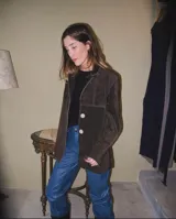 Blazer de cuero genuino color marrón oscuro, estilo oversize, con cuello solapa y cierre frontal de dos botones blancos.