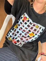 Remera negra de corte holgado con estampado de recuadros con dibujos.