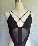 Body negro con breteles finos, escote en V y transparencias en el abdomen.