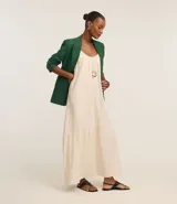 Vestido midi de color negro confeccionado en tejido de viscolino. Cuenta con breteles finos, escote redondo con pliegues frontales y un panel con volado en el ruedo.