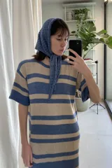 Vestido tejido artesanalmente a rayas horizontales en tonos beige y azul.