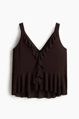 Musculosa de tejido liviano color marrón oscuro, con escote en V pronunciado adornado con volados en cascada en el frente. Posee breteles anchos y un bajo con doble capa de volados.