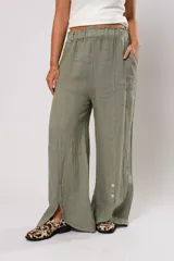 Pantalón verde oliva de lino, corte palazzo, con cintura elástica y aberturas laterales con botones.