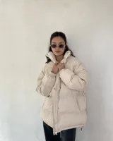 Campera puffer color beige, de corte oversize, con cierre frontal y cuello alto.