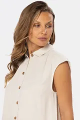 Camisa color beige de lino con botones de madera, cuello clásico y mangas cortas.