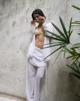 Pantalón blanco de gasa con cintura elastizada y cierre lateral. Incluye pollera superpuesta.