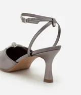 Zapato de tacón color gris con punta fina, tira fina con hebilla en el tobillo y detalle de nudo con strass.
