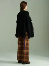 Sweater negro oversize de lana con cuello redondo, bordado central en forma de trenza, laterales con cuadrillé y mangas acampanadas desflecadas.