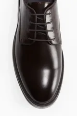 Zapato de vestir Derby de cuero color marrón oscuro, con cordones y suela plana.