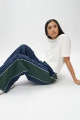 Pantalón de nylon con elástico en la cintura y cordón ajustable, con pliegues en las rodillas.