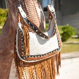 Cartera de cuero vacuno en colores arena, tostado y negro, con manija corta y correa larga ajustable y removible.