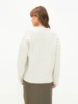 Sweater tejido con trenzas color beige claro, de corte holgado y cuello en V.