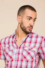 Camisa de manga corta con estampado a cuadros en tonos azul, rojo y blanco. Cierre con botones y tela ligera.