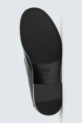 Mocasín de vestir color marrón oscuro, con detalle de borlas en la parte delantera, forro y plantilla interior a tono, horma redonda y suela con ligero tacón.