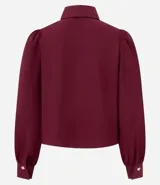 Camisa celeste de crepé con cuello inglés, manga larga abullonada y abotonadura frontal.