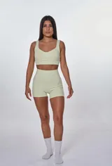 Conjunto deportivo color verde claro, compuesto por un top con breteles anchos y un short ajustado de cintura alta.