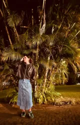 Sweater de cuero color marrón oscuro con cuello redondo y cierre frontal con botones blancos.