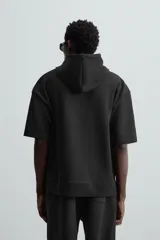 Sudadera negra de algodón con capucha ajustable y mangas cortas.