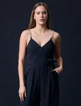 Enterito celeste de crepe marca Luxology, con escote en V cruzado, cintura elastizada, espalda en punto smock y tirantes con detalle de cadenas.