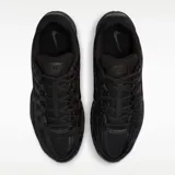 Zapatilla deportiva Nike P-6000, completamente negra, con paneles superpuestos de malla y material sintético brillante, y logo Swoosh en el lateral.