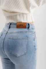 Pantalón jean marrón acampanado con detalle desflecado en el bajo y tiro medio.