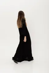 Vestido largo negro de punto con lanilla tipo canelón, corte trapecio y mangas largas.