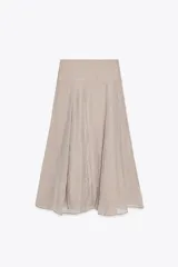 Falda midi color beige de tejido fluido, con tiro medio, cremallera lateral oculta y forro interior combinado.