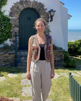 Chaleco gris carbón con bordados florales en terracota y arena, de estilo rústico y folk.