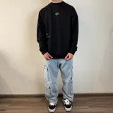 Pantalón jean cargo negro con corte holgado y múltiples bolsillos.